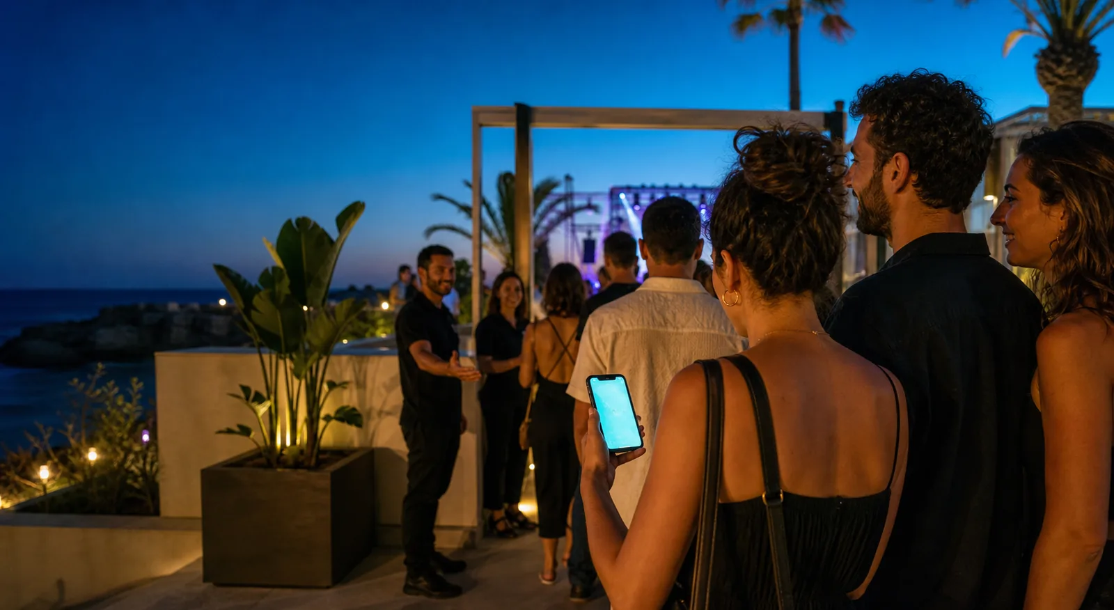 Freunde kommen mit einem digitalen Ticket auf dem Smartphone bei einem Event am Meer an