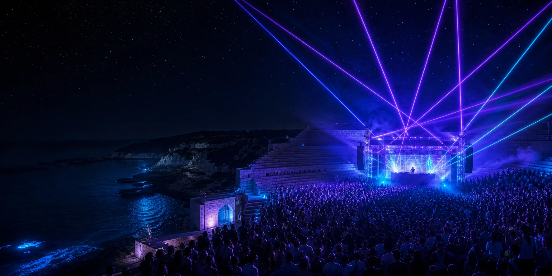 Publikum bei einer DJ- und Lasershow in einem Amphitheater am Meer